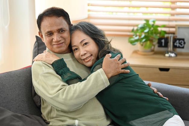 Romantic senior couple relaxing on couch spending time together at home