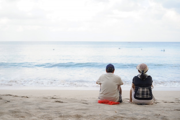 Coppie senior romantiche che si siedono sulla spiaggia