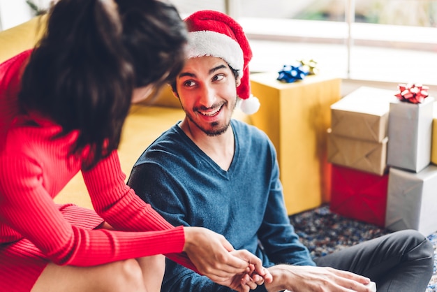 Romantic sweet couple in santa hats having fun and smiling while celebrating new year eve and enjoying spending time together 