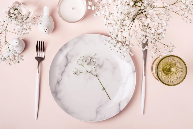 Photo romantic table setting in pink colors. white flowers decor.