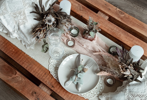 Romantic table setting with candles and dried flowers 