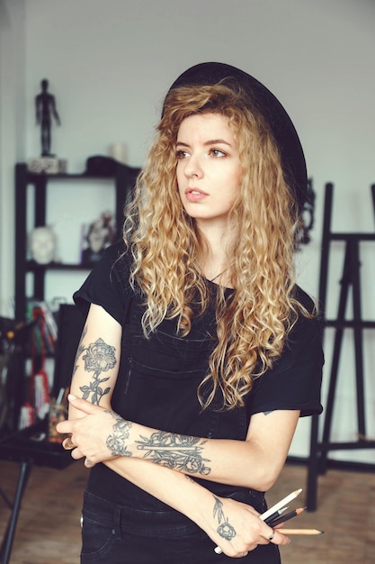 Romantic tattoed curly painter girl in