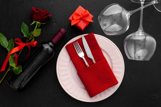 Romantic valentine's day table setting with wine, glasses and red box