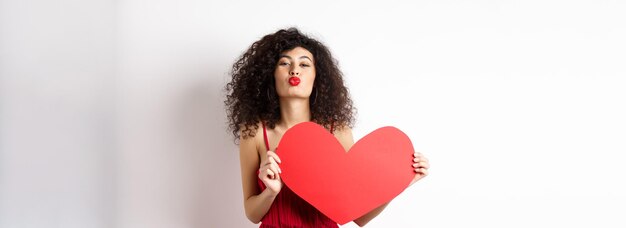 Photo romantic woman in dress showing big red heart pucker lips for kiss and express love express sympathy