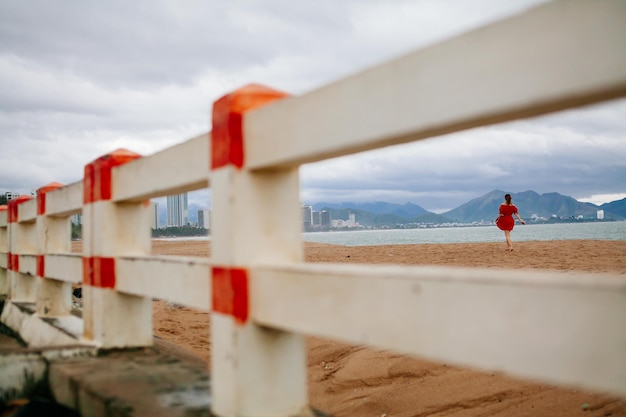 ロマンチックな女性はビーチを歩きます。アジアのビーチと海の景色。