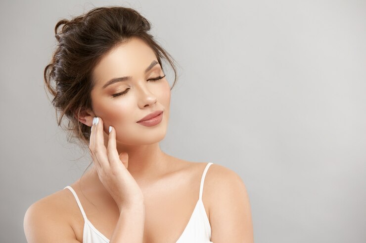 Photo romantic woman with eyes closed touching her face with one arm