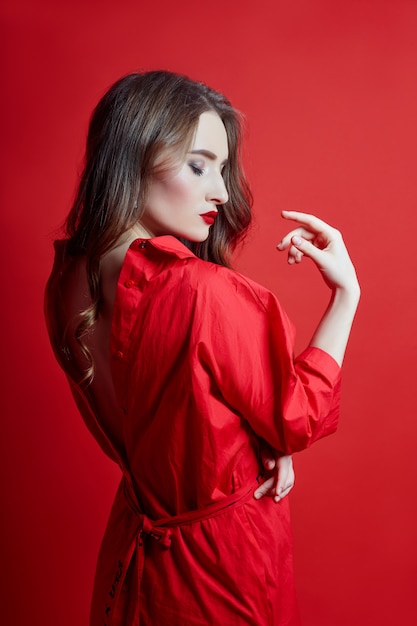 Romantic woman with long blonde hair in red dress