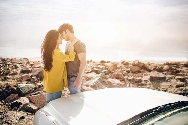 Romantic Young Attractive Couple Watching the Sunset and Kissing with Sports Car.