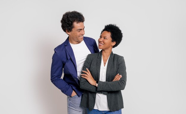 Romantic young business couple smiling and looking at each other while standing on white background