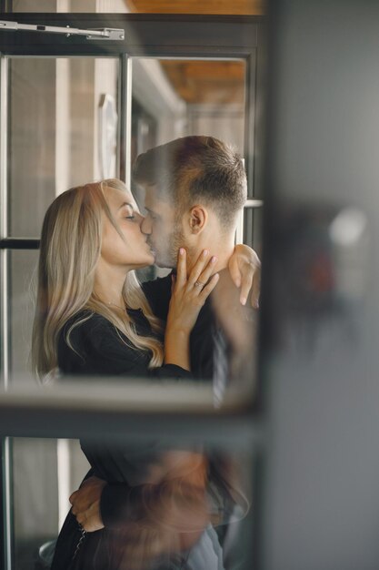 로맨틱한 젊은 부부가 카페 창문에서 포옹하고 있습니다.