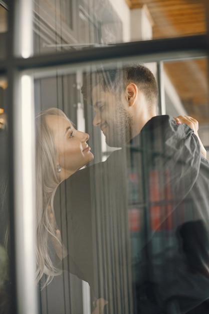 Foto giovani coppie romantiche che abbracciano alla finestra del caffè