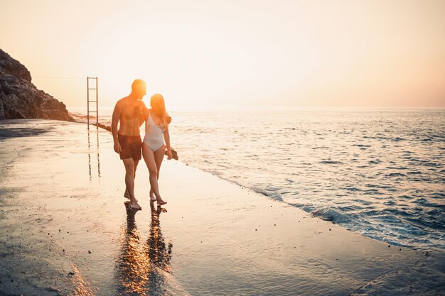 Romantic young couple in love walking together at sunset along
the mediterranean beach summer vacation in a warm country happy
married couple on vacation in turkey selective focus