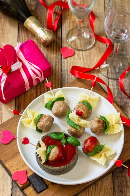 Romantisch diner voor Valentijnsdag of verjaardag Spaghetti gekookt in de vorm van gehaktballen van canapés