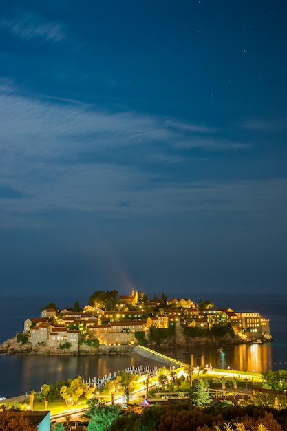 Romantisch eiland Sveti Stefan gloeit in de nacht met het maanlicht