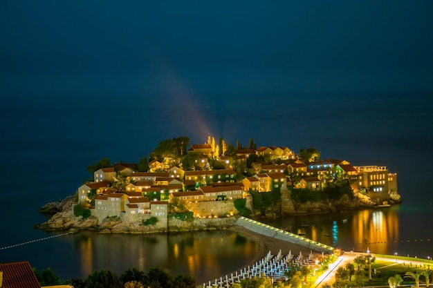 Romantisch eiland sveti stefan gloeit in de nacht met het maanlicht