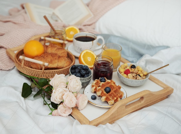 Romantisch ontbijt met koffiewafels, jus d'orange en rozenbloemen