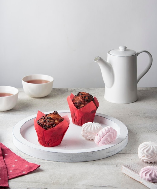 Romantisch ontbijt 's ochtends thee en cupcakes op een wit houten dienblad