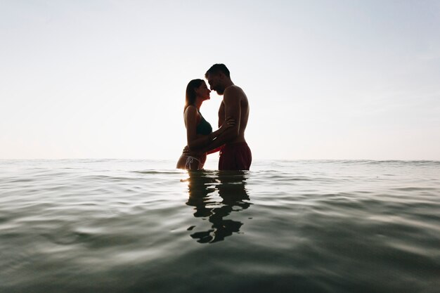 Romantisch paar in de zee bij zonsondergang