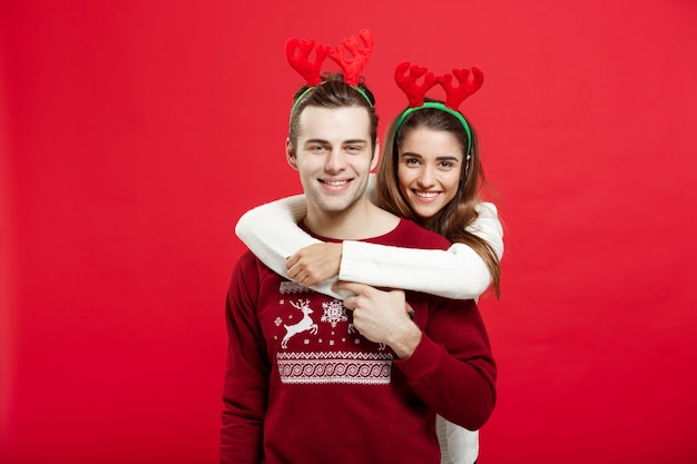 Romantisch paar in een Kerstmissweaters die elkaar koesteren.