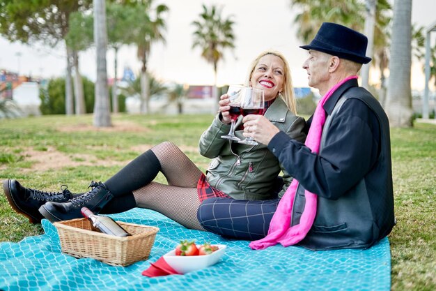 Romantisch paar op middelbare leeftijd roosteren met wijn op het platteland