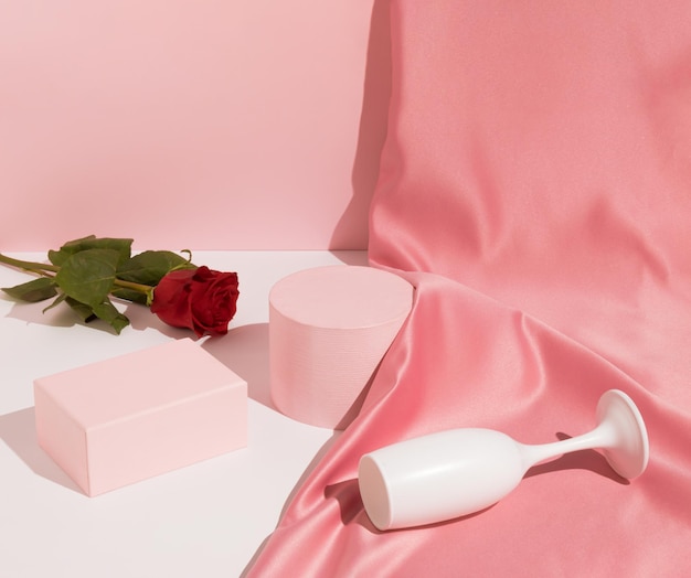 Romantisch roze Valentijnsconcept met satijnen gordijn van wijnglas en roze bloem Product Display Podium