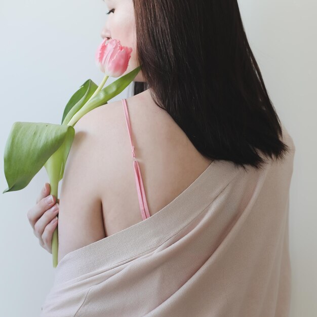 romantisch teder portret van een jonge vrouw met roze verse tulpen