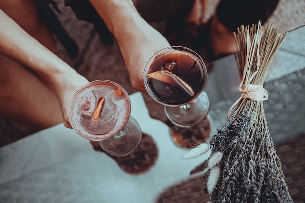 Romantische date. geliefden hand in hand aan de tafel. Cocktail aan de oppervlakte. Liefde concept. Gedroogde lavendel trossen op het oppervlak