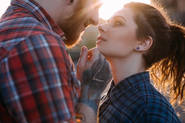 Romantische hipster paar kus. Jeugd relaties achtergrond. Tedere jonge mensen samen close-up, zachte aanraking. Sfeervolle achtergrondverlichting met focus op de voorgrond, liefdesconcept