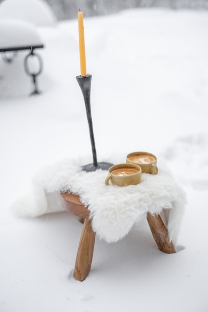 Romantische koffiepauze serveren op wit schapenleer in de sneeuw foto van hoge kwaliteit