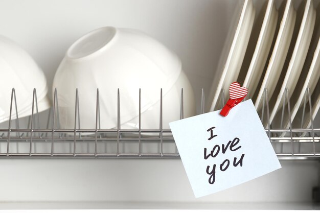 Romantische liefdesverklaring op een plakbriefje in het interieur van de keuken. Liefdes verklaring. Valentijnsdag viering. Kleverige nota met zin ik hou van je!
