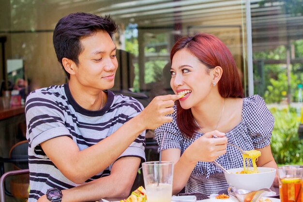 Romantische man die zijn vriendin voedt in een restaurant