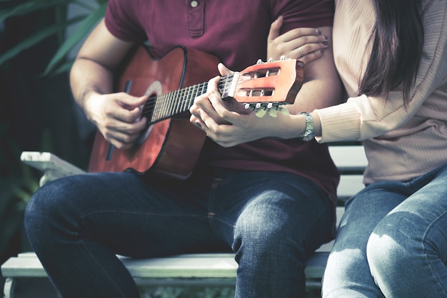 Foto romantische paren die gitaar spelen samen van liefde en valentijnskaartdagconcept.