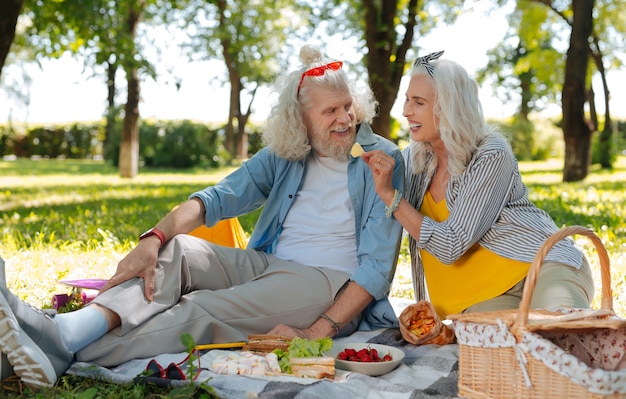 Romantische picknick. Aangenaam ouder echtpaar met een romantische picknick terwijl ze op een date zijn