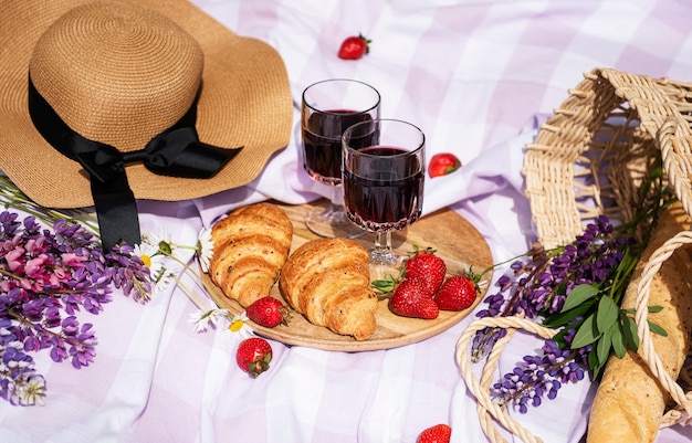 Romantische picknickscène op de zomerdag. Outdoor picknick met wijn en fruit in de open lucht op de achtergrond van groen gras.