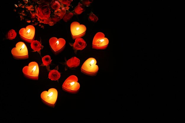 Romantische sfeer met kaarslicht en bloemen op een donkere achtergrond