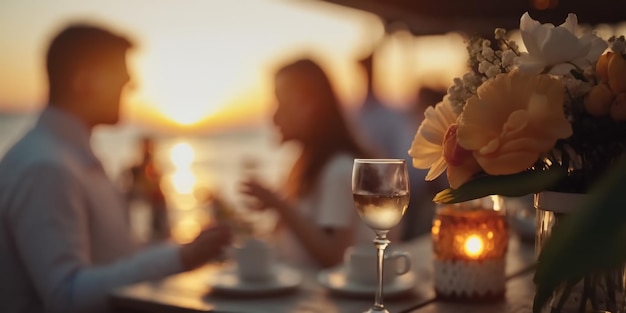 romantische zonsondergang strandcaffee, kopje koffie, zoete cake en bloemen op tafel, romantisch koppel