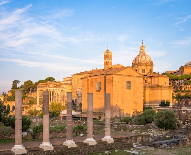 ROME, ITALI - CIRCA AUGUSTUS 2020: zonsopganglicht met blauwe lucht op Romeinse oude architectuur.