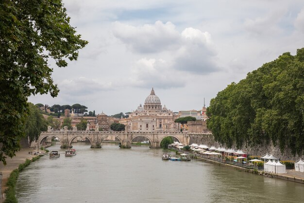 Rome, Italië - 22 juni 2018: Panoramisch uitzicht op de pauselijke basiliek van St. Peter (St. Peter's Basilica) in het Vaticaan en de rivier de Tiber met brug in Rome. Zomerdag