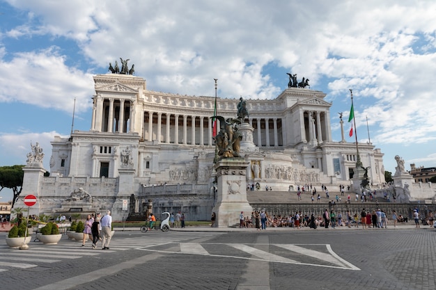 イタリア、ローマ-2018年6月19日：ローマのヴェネツィア広場にあるヴィットリアーノまたはアルターレデッラパトリアとしても知られるヴィットリオエマヌエーレ2世記念碑のパノラマ正面図。夏の日と青い空