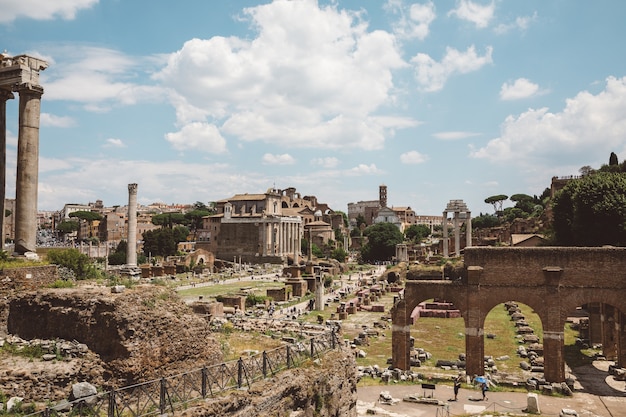 Rome, Italy - June 20, 2018: Panoramic view of Roman forum, also known by Forum Romanum or Foro Romano. It is a forum surrounded by ruins of ancient government buildings at center of city of Rome