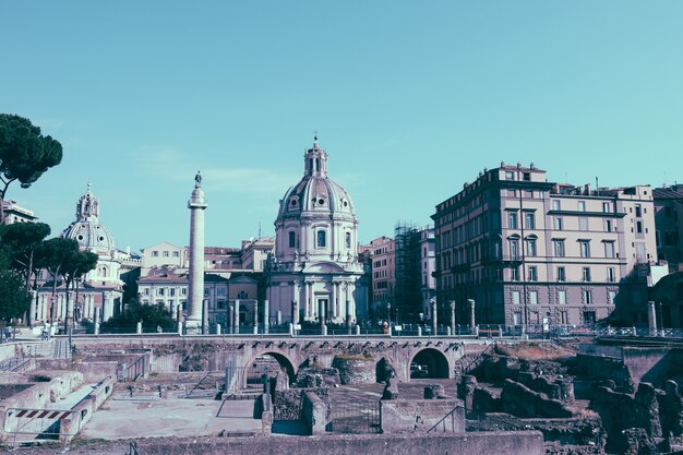 Rome, Italy - June 20, 2018: Panoramic view of Trajan's Forum and Column in Rome, far away the Church of the Most Holy Name of Mary. Summer day and blue sky