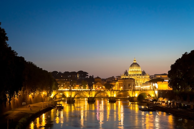 ROME, ITALY - JUNE 2020: sunset panorama on Tiber river bridge with Saint Peter Cathedral dome (Vatican City) in background - Rome, Italy