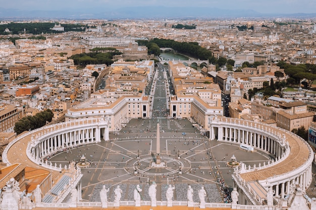 이탈리아 로마 - 2018년 6월 22일: 성 베드로 대성당(성 베드로 대성당)에서 성 베드로 광장과 로마 시의 탁 트인 전망. 여름날과 사람들이 광장을 걷다