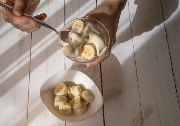 Romig bananenroomijs met stukjes fruit op houten tafel