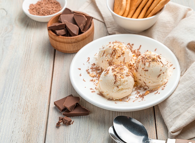 Romig dessert, ijsballen met chocolade op een lichte muur. Close-up, kopieer ruimte.