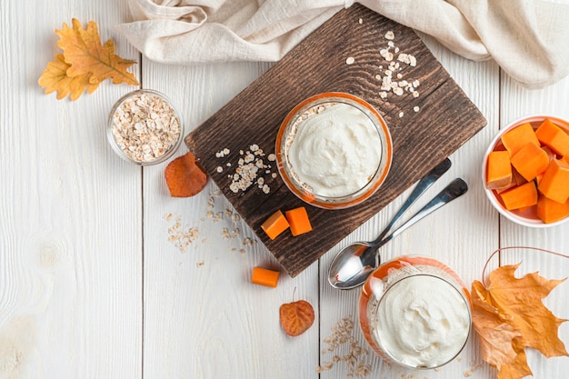 Romig dessert met pompoen en granen op een witte achtergrond met bladeren vegetarisch herfstdessert