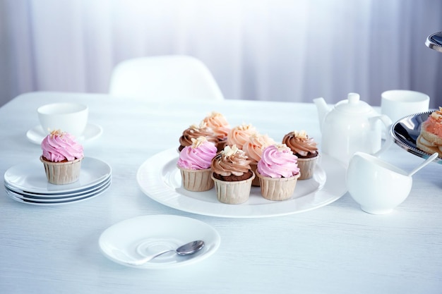 Romige cupcakes en thee op tafel binnenshuis