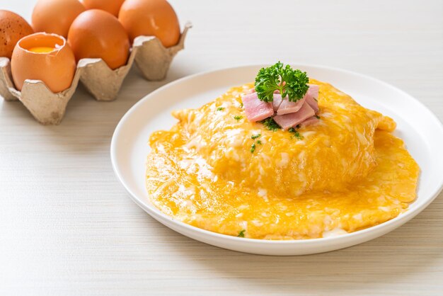 Romige omelet met ham op rijst of rijst met ham en zachte omelet