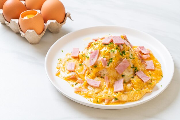 Romige omelet met ham op rijst of rijst met ham en zachte omelet