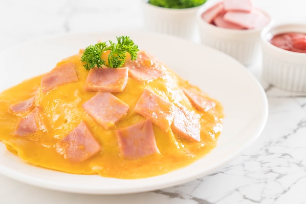 Romige omelet met ham op rijst